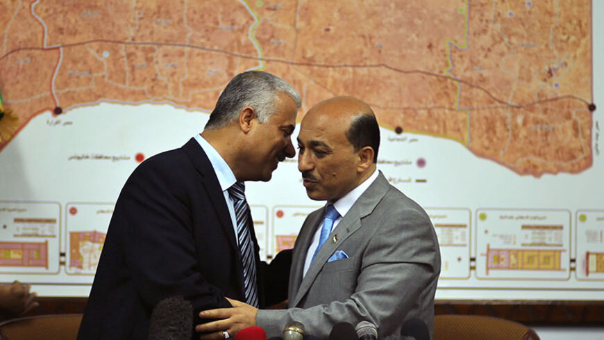 Palestinian Minister of Housing and Public Works Mufeed Al-Hassayna (R) shakes hands with former Hamas government Minister of Housing Youssef Graze during office handover ceremony in Gaza City June 4, 2014. Islamist Hamas handed control of two government ministries in Gaza to members of the new Palestinian unity government on Wednesday, a further sign of reconciliation between the rival factions after the collapse of peace talks with Israel. In Gaza, new cabinet ministers Saleem Al-Saqqa, a Gaza lawyer, and