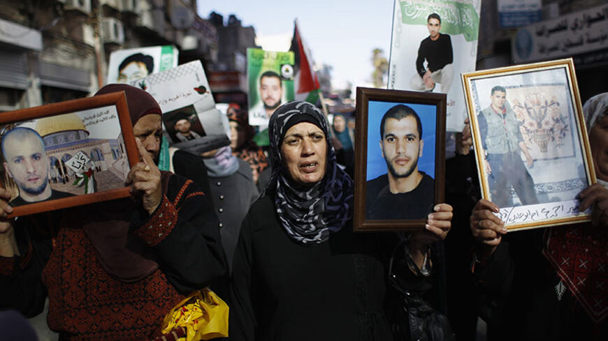 Palestinians hold pictures of prisoners during a demonstration in support of Palestinian prisoners on hunger strike in Israeli jails, in the West Bank city of Ramallah June 7, 2014. U.N. Secretary-General Ban Ki-moon voiced concerns on Friday about the worsening health of Palestinian hunger strikers in Israeli detention and demanded that they either be formally charged or released immediately. Several dozen Palestinians on hunger strike, protesting Israel's use of administrative detention to keep them behin