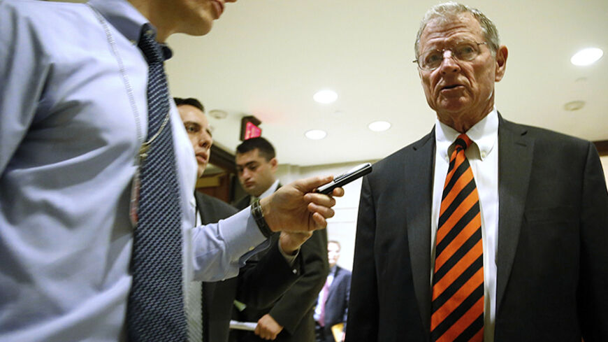 Senator James Inhofe (R-OK) (R) is trailed by reporters outside of a closed-door Senate Armed Services Committee briefing on the Bergdahl prisoner swap at the U.S. Capitol in Washington June 10, 2014. The White House has been trying to appease angry lawmakers since U.S. President Barack Obama announced on May 31 that U.S. Army Sergeant Bowe Bergdahl had been exchanged for the five inmates from the U.S. military prison at Guantanamo Bay in Cuba. REUTERS/Jonathan Ernst (UNITED STATES - Tags: POLITICS MILITARY