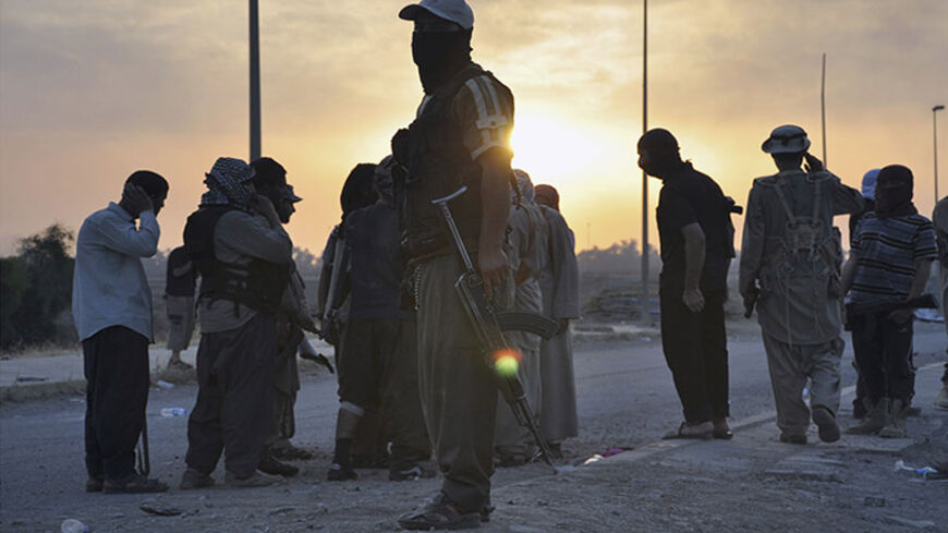 Fighters of the Islamic State of Iraq and the Levant (ISIL) stand guard at a checkpoint in the northern Iraq city of Mosul, June 11, 2014. Since Tuesday, black clad ISIL fighters have seized Iraq's second biggest city Mosul and Tikrit, home town of former dictator Saddam Hussein, as well as other towns and cities north of Baghdad. They continued their lightning advance on Thursday, moving into towns just an hour's drive from the capital. Picture taken June 11, 2014. REUTERS/Stringer (IRAQ - Tags: CIVIL UNRE