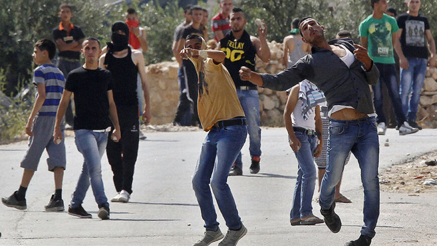 Palestinians hurl stones at Israeli troops near the West Bank City of Hebron June 13, 2014. Israeli forces are searching for three Jewish teenagers who went missing in the occupied West Bank late on Thursday, the military said on Friday. As media speculated that the trio might have been abducted, large numbers of Israeli soldiers scoured the countryside around the flashpoint city of Hebron, carrying out house-to-house searches in neighbouring villages and blocking roads. REUTERS/Ammar Awad (WEST BANK - Tags
