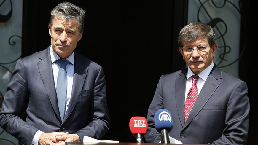 NATO Secretary-General Anders Fogh Rasmussen (L) and Turkey's Foreign Minister Ahmet Davutoglu attend a news conference in Ankara June 16, 2014. REUTERS/Umit Bektas (TURKEY - Tags: POLITICS) - RTR3U04T