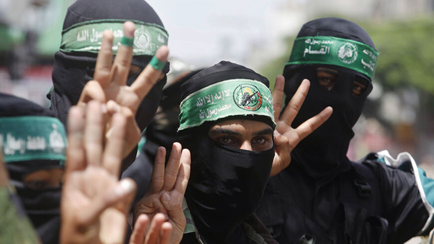 Masked Palestinians supporting Hamas gestures "three" as a reference to Israeli teenagers who went missing during a rally in support of Palestinians in the West Bank and against an arrest campaign by Israeli troops, in the central Gaza Strip June 20, 2014. Israeli troops killed a Palestinian teenager in the occupied West Bank on Friday and arrested 25 people, pursuing a weeklong crackdown against Islamist militants and house-to-house searches for three Israeli teenagers who went missing eight days ago. REUT