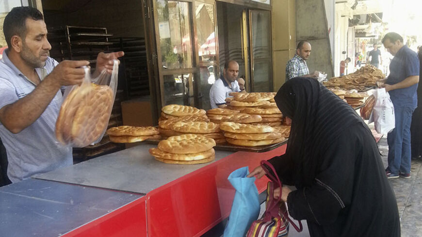 A woman buys bread at a bakery in the city of Mosul, June 24, 2014. U.S. Secretary of State John Kerry held crisis talks with leaders of Iraq's autonomous Kurdish region on Tuesday urging them to stand with Baghdad in the face of a Sunni insurgent onslaught that threatens to dismember the country.  Picture taken June 24, 2014. REUTERS/Stringer (IRAQ - Tags: CIVIL UNREST POLITICS CONFLICT BUSINESS FOOD SOCIETY) - RTR3VNJJ