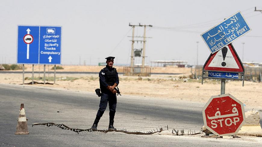 A Jordanian police stands guard at a checkpoint near the Jordanian Karameh border crossing at the Jordanian-Iraqi border, near Ruweished city, June 25, 2014. REUTERS/Muhammad Hamed (JORDAN - Tags: POLITICS CIVIL UNREST) - RTR3VOZ6