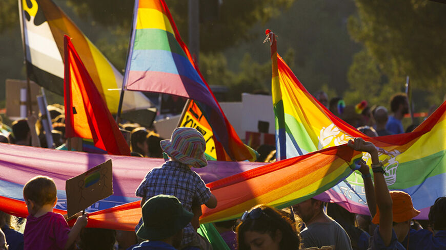 Participants hold rainbow flags during the 12th annual gay pride parade in Jerusalem August 1, 2013. Some 2500 people on Thursday took part in the annual parade in Jerusalem. REUTERS/Ronen Zvulun (JERUSALEM - Tags: SOCIETY) - RTX127G3