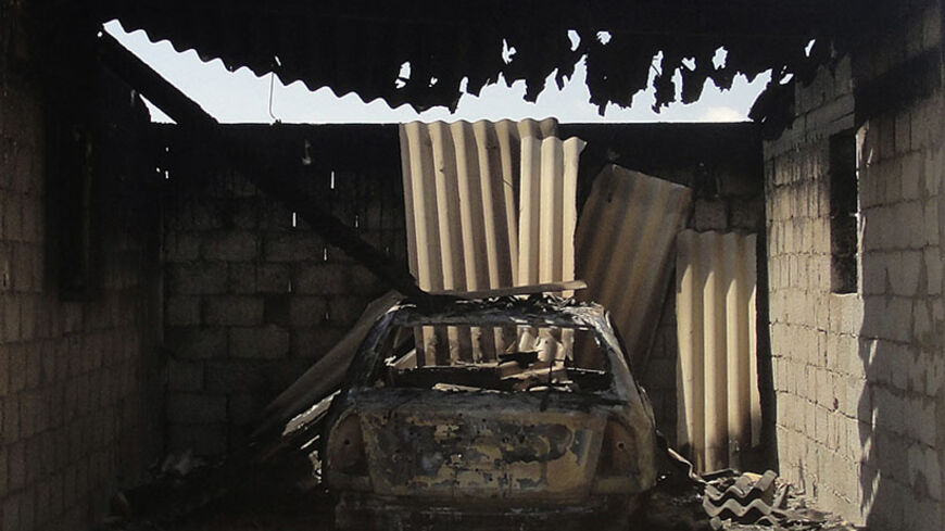 A burnt car is seen in a damaged house after assaults on militants by the Egyptian Army, in a village on the outskirts of Sheikh Zuweid, near the city of El-Arish in Egypt's Sinai peninsula September 10, 2013. Egypt has tightened control of crossings from the Sinai peninsula and continued assaults on militants after an Islamist group based there said it tried to kill the interior minister in Cairo last week, the state news agency reported on Monday. REUTERS/Stringer  (EGYPT - Tags: POLITICS) - RTX13GQ7