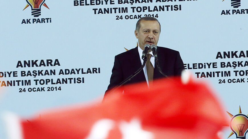 Turkey's Prime Minister Tayyip Erdogan addresses his supporters during a meeting of his ruling AK Party (AKP) in Ankara January 24, 2014. Turkey received a vote of confidence in its underlying economic health on Thursday, with foreign investors lapping up a $2.5 billion eurobond issue even as a corruption scandal swirled and the central bank intervened to prop up the lira. The graft investigation, one of the biggest threats to Erdogan's 11-year rule, has shaken Turkey in recent weeks, helping send the lira 