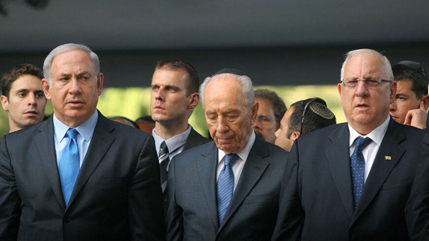 Israel's Prime Minister Benjamin Netanyahu (L) stands with President Shimon Peres and Speaker of the parliament Reuven Rivlin (R) during a memorial ceremony on Mount Herzl military cemetery in Jerusalem marking the anniversary of the assassination of Prime Minister Yitzhak Rabin October 20, 2010. Israel marks on Wednesday the 15th anniversary of Rabin's assassination by an ultra-nationalist Jew.  REUTERS/Alex Kolomoisky/Pool (JERUSALEM - Tags: POLITICS ANNIVERSARY) - RTXTN9O