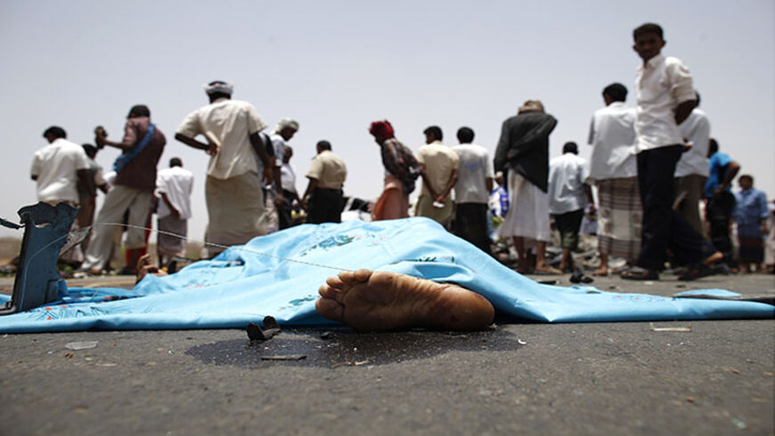 ATTENTION EDITORS - VISUAL COVERAGE OF SCENES OF INJURY OR DEATH 

A covered body is seen as policemen and people check the scene of a collision on a highway leading to a border crossing between Yemen and Saudi Arabia May 18, 2013. At least 13 people were killed as two cars ran into each other and caught fire after the collision, burning some occupants to death, police officials at the scene said. Yemen is among the countries with the world's highest rates of traffic fatalities. Traffic accidents claimed th