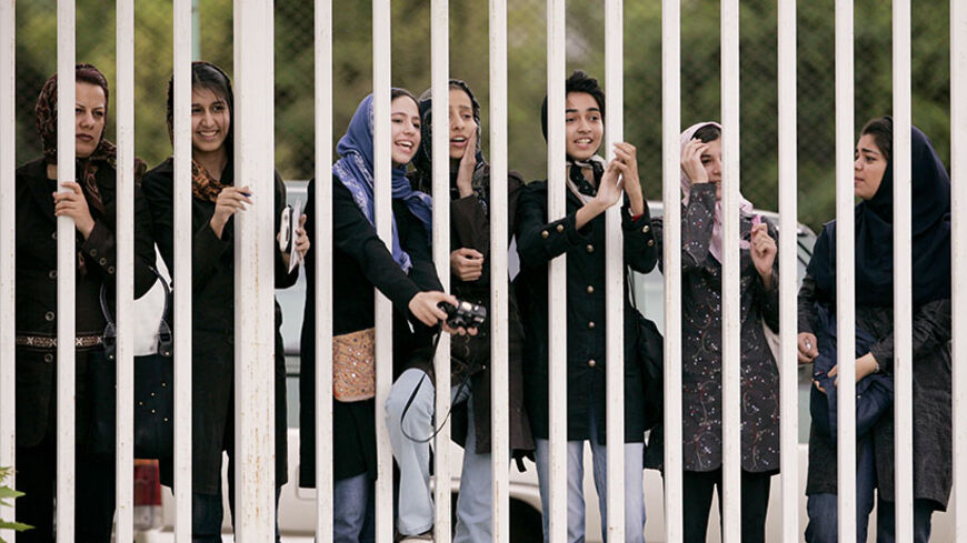 Iranian women watch the practice session of Iran's national soccer team from behind the railings as they banned from entering the stadium at Azadi (freedom) sport complex in Tehran, Iran May 21, 2006.  WORLD CUP 2006 PREVIEW     REUTERS/Morteza Nikoubazl - RTR1DLXK