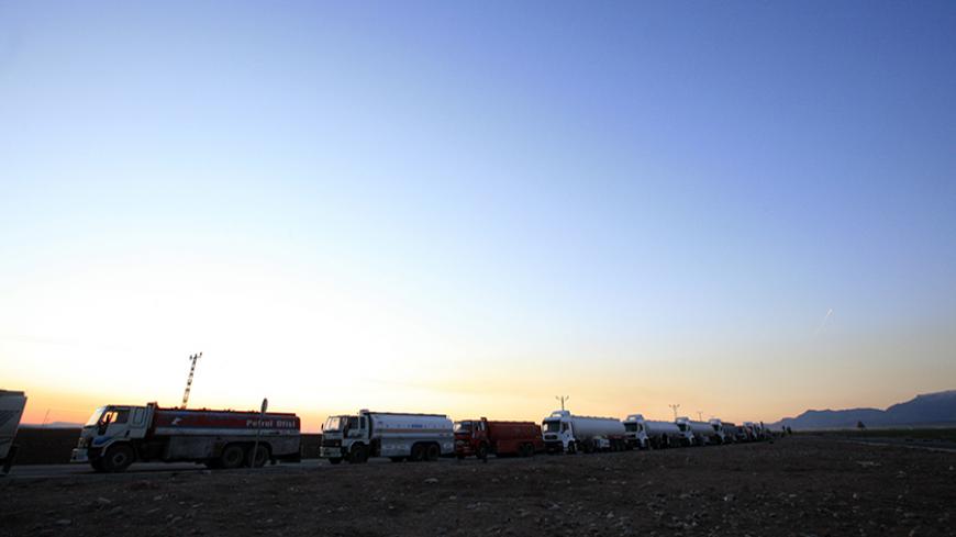 Turkish trucks and tankers, shuttling between Turkey and Iraq, queue on a road leading to the Habur border gate in southeastern Turkey, before crossing into Iraq with their goods, February 23, 2008. Turkey's exports to Iraq jumped nine percent last year to $2.8 billion and its influence can be felt across northern Iraq in the form of supermarkets, consumer goods, construction firms and traders from all over Turkey. To match feature TURKEY-IRAQ/CONFLICT    REUTERS/Fatih Saribas  (TURKEY) - RTR1XKEF
