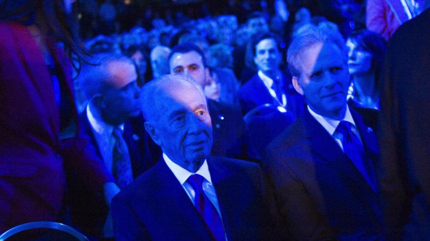 Israel's President Shimon Peres (C) and Israel's Ambassador to the U.S. Michael Oren (R) are bathed in blue light, save for the red focusing light of a camera, as they take their seats in the audience at the American Israel Public Affairs Committee (AIPAC) policy conference in Washington, March 4, 2012. REUTERS/Jonathan Ernst (UNITED STATES - Tags: POLITICS) - RTR2YUFE