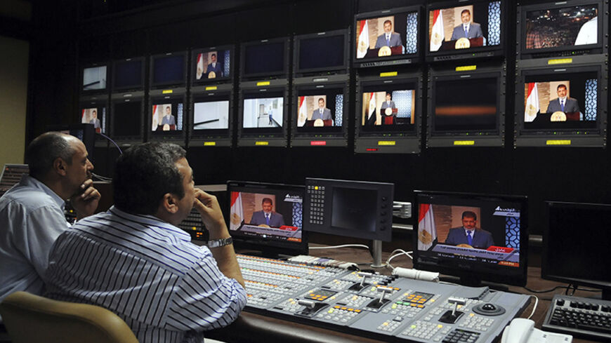 Muslim Brotherhood's President-elect Mohamed Morsy is seen on screens at the Egyptian Television headquarters control room during his first televised address to the nation in Cairo June 24, 2012. Morsy's victory in Egypt's presidential election takes the Muslim Brotherhood's long power struggle with the military into a new round that will be fought inside the institutions of state themselves and may force new compromises on the Islamists. Picture taken June 24, 2012. To match Analysis EGYPT-ELECTION/STRUGGL