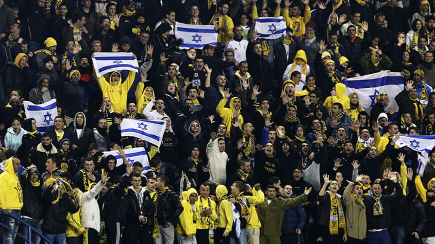 Supporters of Beitar Jerusalem cheer for their team during a soccer match against Maccabi Umm el-Fahm at Teddy Stadium in Jerusalem January 29, 2013. Hundreds of police officers and stewards secured the Israeli State Cup match on Tuesday in which Premier League Beitar Jerusalem, supported by a group of vehement anti-Arab fans, host Arab side Maccabi Umm el-Fahm. A racist element among Beitar fans caused uproar in the Jewish state on Saturday when they held up banners during a Premier League match to protest