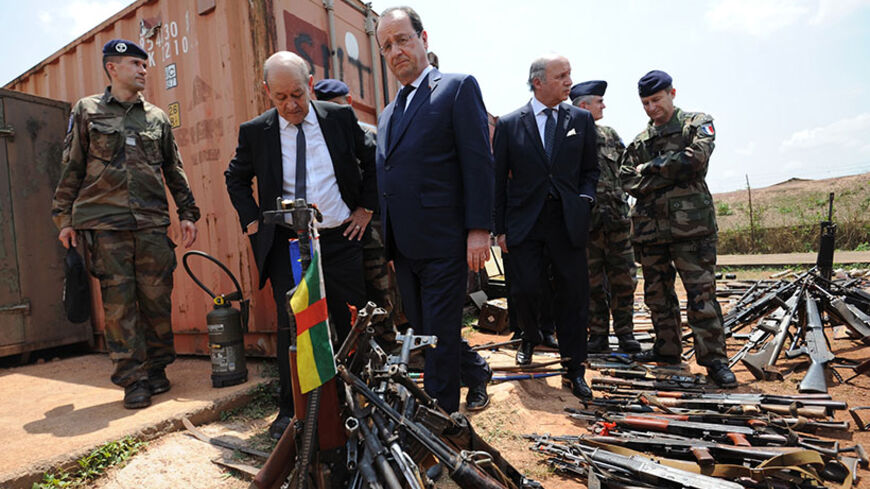 French President Francois Hollande (C), French Foreign Minister Laurent Fabius (3rdR) and French Defense Minister Jean-Yves Le Drian (2ndL) inspect arms confiscated from ex-Seleka rebels and "anti-balaka" militia by the French military of operation Sangaris at a French military base in Bangui, February 28, 2014. President Francois Hollande flew to Central African Republic on Friday to tell its leaders and French forces stationed there that France will work to stop the country splitting in two. REUTERS/Sia K