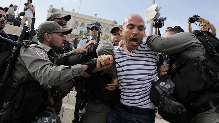 Israeli border policemen detain a member of media during clashes at protest against a parade by Israelis marking Jerusalem Day, at Damascus Gate in Jerusalem's Old City May 28, 2014. Nine Palestinians were detained on suspicion of throwing stones at policemen and participants of the parade, an Israeli police spokesman said on Wednesday. Jerusalem Day marks the anniversary of Israel's capture of the Eastern part of the city during the 1967 Middle East War. In 1980, Israel's parliament passed a law declaring 