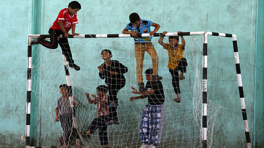 Syrian and Palestinian refugee children climb up a goalpost before the start of a soccer match in the Al-Baqaa Palestinian refugee camp, near Amman June 17, 2014. The football league between young Syrian and Palestinian refugees and Jordanian youth is organized by Oxfam and the al-Baqaa youth club to commemorate World Refugee Day, which falls on June 20. The matches aim to foster positive relationships between communities, fighting exclusion and marginalization, while promoting trust and friendship, accordi