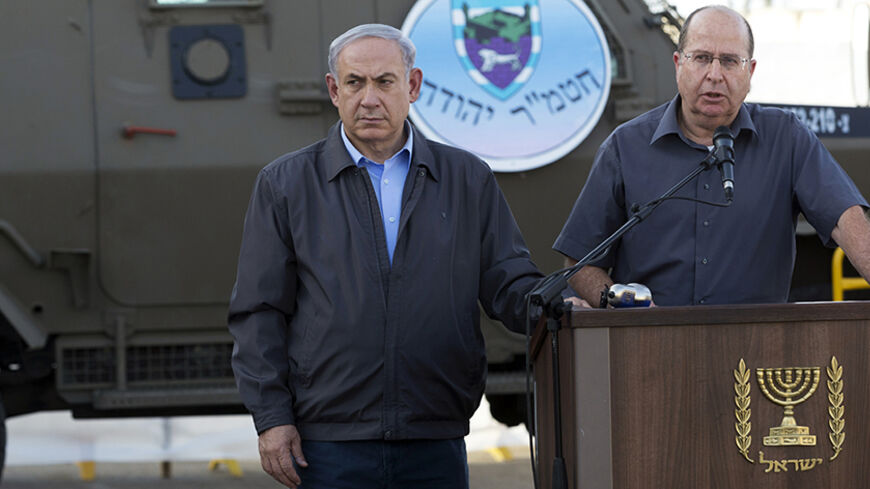 Israeli Prime Minister Benjamin Netanyahu (L) listens as Defense Minister Moshe Ya'alon gives a statement regarding the military operation to locate three missing Israeli teenagers, at a military base near the West Bank Jewish settlement of Beit Haggai, near Hebron June 19, 2014. Israeli forces traded gunfire with Palestinians on Thursday, the military said, in the fiercest street battles in the occupied West Bank since a search began for the three Israeli teenagers missing for a week. REUTERS/Jim Hollander
