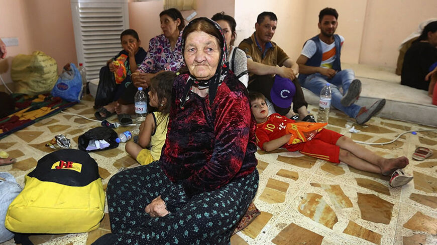 Christian families, who fled from the violence in Mosul, gather at a building which was used as a social club in Arbil, in Iraq's Kurdistan region June 26, 2014. Iraqi forces launched an airborne assault on rebel-held Tikrit on Thursday with commandos flown into a stadium in helicopters, at least one of which crashed after taking fire from insurgents who have seized northern cities.  REUTERS/Stringer (IRAQ - Tags: CIVIL UNREST POLITICS) - RTR3VXHK