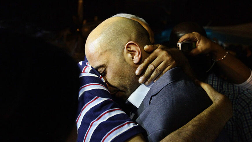 Tunisian diplomat Al-Aroussi Kontassi (C) hugs a family member upon his arrival at a military airport at Aouina in Tunis early June 30, 2014. The Tunisian diplomat and an embassy worker kidnapped earlier this year by unknown gunmen in Libya arrived at dawn on Monday at a Tunis airport after being freed on Sunday.  REUTERS/Anis Mili  (TUNISIA - Tags: CIVIL UNREST POLITICS) - RTR3WCZP