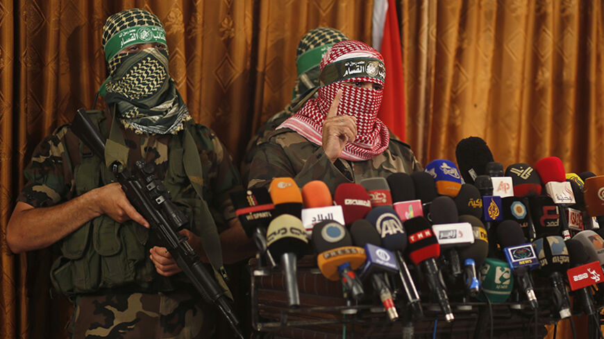 Hamas' armed wing spokesman speaks during a news conference in Gaza City July 3, 2014. The spokesman said Israel was breaking the 2012 ceasefire agreement and the group would act according to developments on the ground. He said Israel would pay a heavy price in any upcoming war. Israel said on Thursday it was beefing up its forces along its frontier with the Gaza Strip, in what it called a defensive deployment in response to persistent Palestinian cross-border rocket attacks. REUTERS/Mohammed Salem (GAZA - 