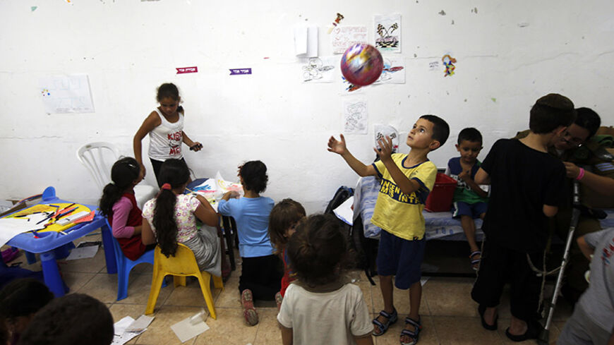 Israeli children play inside a bomb shelter in the southern city of Ashkelon July 10, 2014. At least 74 Palestinians, most of them civilians, have been killed in Israel's Gaza offensive, Palestinian officials said on Thursday, and militants kept up rocket attacks on Tel Aviv and other cities in warfare showing no signs of ending soon. REUTERS/Ronen Zvulun (ISRAEL - Tags: POLITICS CIVIL UNREST SOCIETY) - RTR3Y0MI