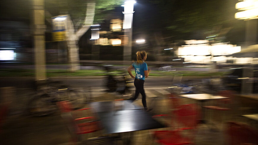 A woman runs for shelter in a nearby office building as an air raid siren, warning of incoming rockets, sounds in a main street in Tel Aviv July 11, 2014. Prime Minister Benjamin Netanyahu said on Friday Israel has attacked more than 1,000 targets during a four-day-old offensive against Gaza militants and that "there are still more to go".  REUTERS/Nir Elias (ISRAEL - Tags: POLITICS CIVIL UNREST CONFLICT) - RTR3Y7ZM