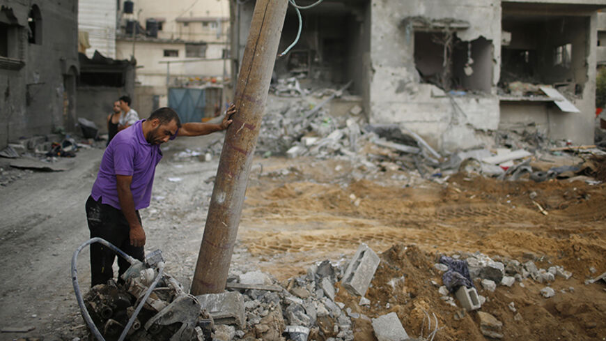 A Palestinian man, who is a relative of Tayseer Al-Batsh's family, reacts next to the rubble of Al-Batsh's family house, which police said was destroyed in an Israeli air strike in Gaza City July 13, 2014. The Israeli air strike on the home of Al-Batsh, Gaza's police chief, killed 18 people on Saturday, Gaza's health ministry said, and Hamas fired the largest salvo of rockets yet on Tel Aviv since the start of the Jewish state's offensive in the Palestinian enclave.The strike on the home of Al-Batsh in Gaza