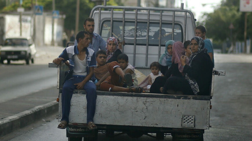 Palestinians, who fled their homes that are adjacent to the border with Israel, ride in a truck as they make their way to stay in a United Nations-run school in Gaza City July 13, 2014. An Israeli air strike on the home of Gaza's police chief killed 18 people on Saturday, Gaza's health ministry said, and Hamas fired the largest salvo of rockets yet on Tel Aviv since the start of the Jewish state's offensive in the Palestinian enclave. Israel's offensive has killed 145 Palestinians since Tuesday. Gaza medica