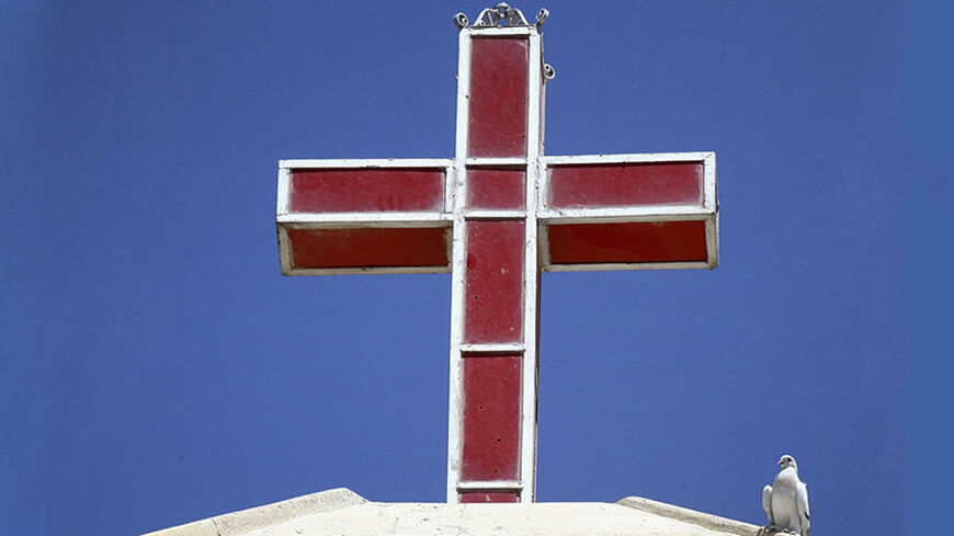 A white dove perches near a cross atop a church in Telkaif near Mosul, in the province of Nineveh, July 20, 2014. The head of Iraq's largest church said on Sunday that Islamic State militants who drove Christians out of Mosul were worse than Mongol leader Genghis Khan and his grandson Hulagu who ransacked medieval Baghdad. Chaldean Catholic Patriarch Louis Raphael Sako led a wave of condemnation for the Sunni Islamists who demanded Christians either convert, submit to their radical rule and pay a religious 