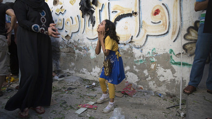 A Palestinian girl reacts at the scene of an explosion that medics said killed eight children and two adults, and wounded 40 others at a public garden in Gaza City July 28, 2014. Locals blamed the blast on an Israeli air strike, but Israel denied responsibility, saying it was a misfire by a rocket launched by Hamas militants. REUTERS/Finbarr O'Reilly (GAZA - Tags: POLITICS MILITARY CIVIL UNREST CONFLICT) - RTR40F6P