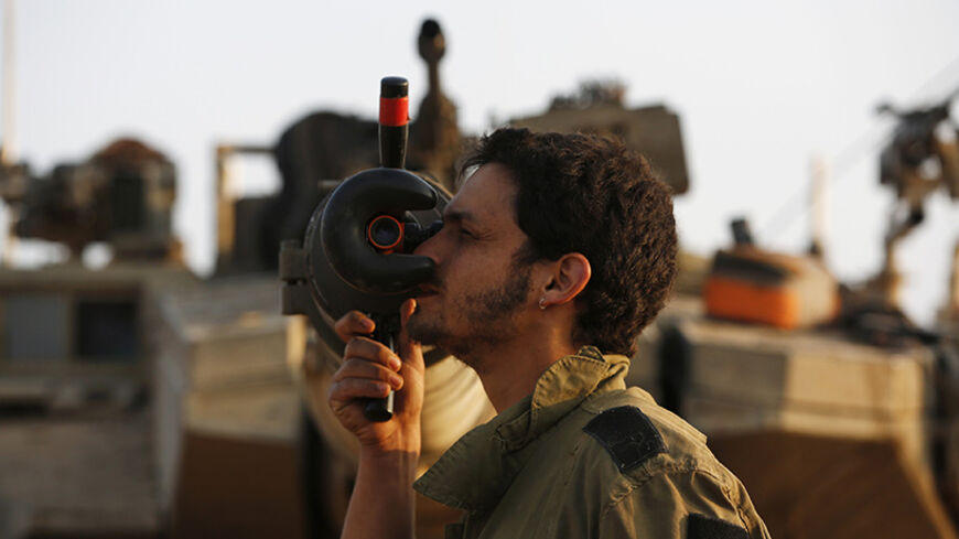 An Israeli soldier adjusts sights on a tank at a staging area outside the northern Gaza Strip July 29, 2014. Israel's military pounded targets in the Gaza Strip on Tuesday after Prime Minister Benjamin Netanyahu said his country should prepare for a long conflict in the Palestinian enclave, squashing any hopes of a swift end to 22 days of fighting. Israel launched its offensive on July 8 with the aim of halting rocket attacks by Hamas and its allies. It later ordered a land invasion to find and destroy the 