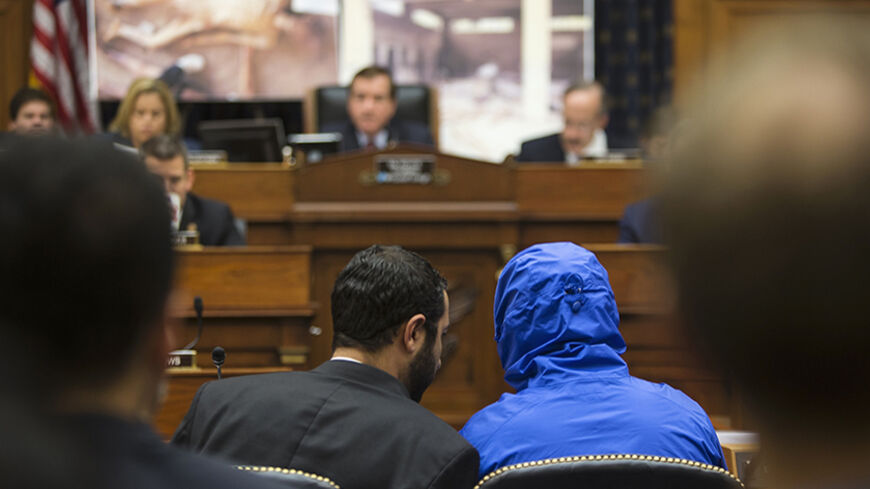 ATTENTION EDITORS - VISUAL COVERAGE OF SCENES OF INJURY OR DEATH
The man credited with smuggling 50,000 photos said to document Syrian government atrocities, a Syrian Army defector known by the protective alias Caesar (disguised in a hooded blue jacket), listens to his interpreter as he prepares to speak at a briefing to the House Foreign Affairs Committee on Capitol Hill in Washington July 31, 2014. REUTERS/Jonathan Ernst (UNITED STATES - Tags: POLITICS MILITARY CONFLICT) TEMPLATE OUT - RTR40T2R