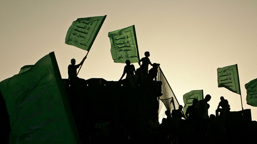 Hamas supporters wave Hamas flags on the now Egyptian and Palestinian border during an Israeli pullout celebration ceremony in Rafah south of Gaza Strip September 22, 2005. Israel on Thursday dismantled its last military base in a pocket of the northern West Bank where it had evacuated four small settlements, completing the final stage of a "disengagement" plan. REUTERS/Ahmed Jadallah - RTRP2HW