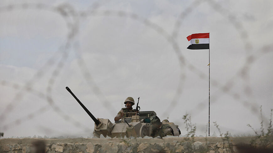 An Egyptian soldier keeps guard on the border between Egypt and southern Gaza Strip July 1, 2013. Egyptian soldiers and members of Palestinian security forces loyal to Hamas are on alert to guard the border area after massive protests in Egypt, Hamas officials said. REUTERS/Ibraheem Abu Mustafa (GAZA - Tags: POLITICS) - RTX118II