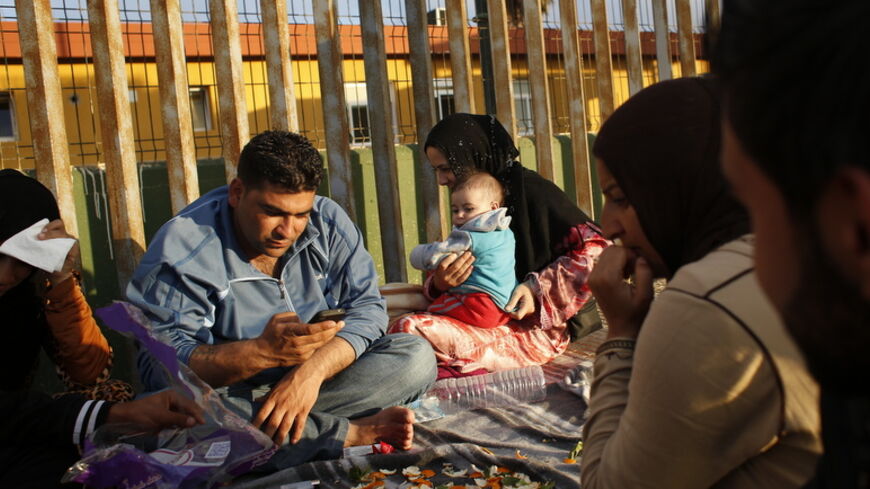 Syrian refugees pass the time outside a refugee centre in Spain's north African enclave Melilla December 6, 2013. Melilla is a small Spanish enclave on Morocco's Mediterranean coast. Armed guards and razor wire lining the 12-km (7.5-mile) frontier around the town have long discouraged Africans fleeing poverty and conflict from seeing Melilla as a gateway to Europe, 180 km (110 miles) away across open water. But desperation has driven many migrants to fetch up at the gates, turning the port town of 80,000 in
