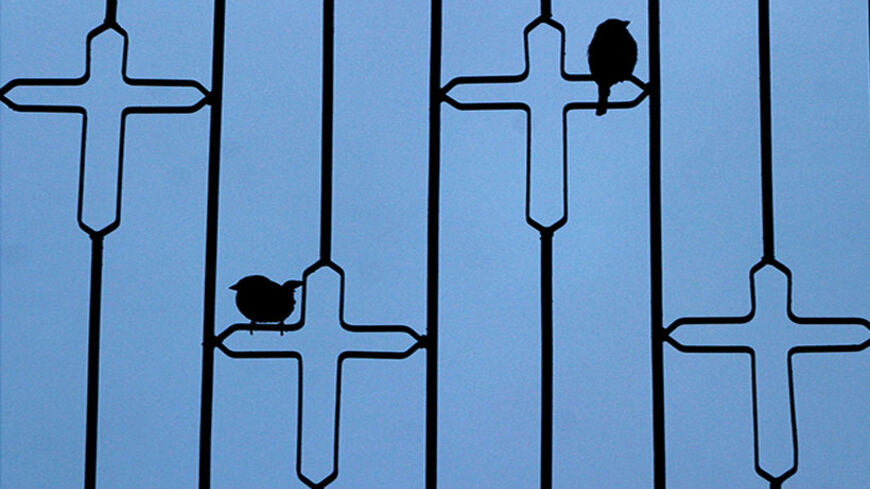 Sparrows sit on crosses at St. Matthew's monastery on Mount Maqloub, northeast of Mosul in Northern Iraq, some 400 km northwest of Baghdad January 7, 2004. [The Assyrian Orthodox Christmas is celebrated today with reference to the Julian calendar, which has a difference of two weeks to the Gregorian calendar.] - RTXMDTW