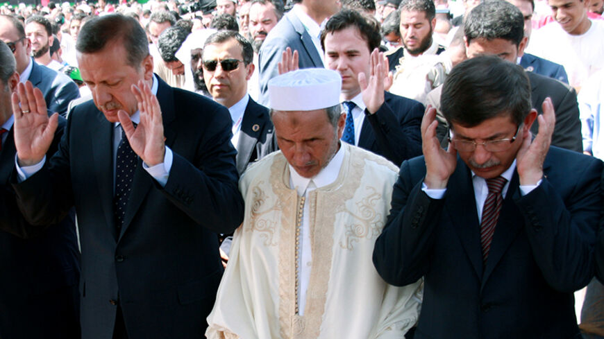 Turkish Prime Minister Recep Tayyip Erdogan (L) attends Friday prayers with Libya's interim leader Mustafa Abdel Jalil (C) and Turkish Foreign Minister Ahmet Davutoglu (R) in Tripoli's renamed "Martys' Square" on September 16, 2011. Erdogan is on the final leg of his "Arab Spring Tour", which has taken him to Egypt and Tunisia. AFP PHOTO/MAHMOUD TURKIA (Photo credit should read MAHMUD TURKIA/AFP/Getty Images)