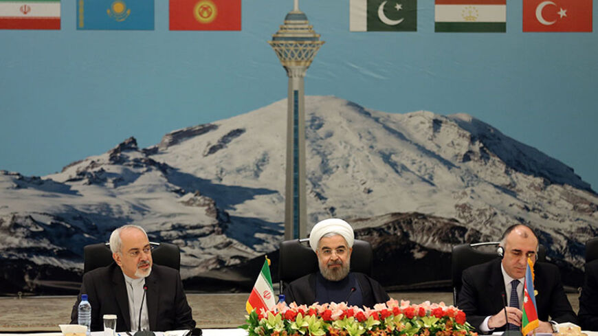 Seated between Iranian Foreign Minister Mohammad Javad Zarif (L) and Azerbaijan's Foreign Minister Elmar Mammadyarov (R), the Islamic republic's President Hassan Rouhani opens a two-day ministerial conference of the Economic Cooperation Organisation (ECO), which groups 10 Asian and Eurasian countries, in Tehran on November 26, 2013.      AFP PHOTO / ATTA KENARE        (Photo credit should read ATTA KENARE/AFP/Getty Images)
