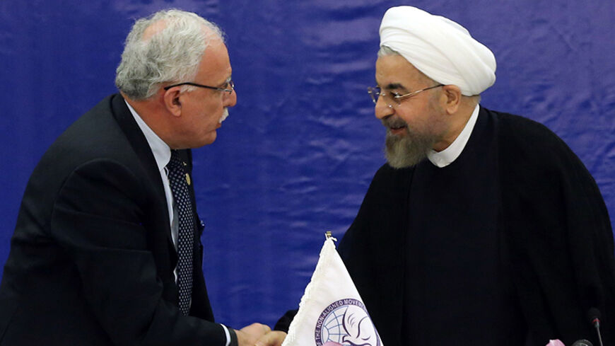 Palestinian Foreign Minister Riyad al-Maliki (L) and Iranian President Hassan Rouhani shake hands during a meeting in Tehran held by the Palestine Committee of the Non-Aligned Movement (NAM) on August 4, 2014 on the situation in Gaza. Rouhani denounced the inaction of the Security Council of the United Nations response to the "slaughter" of Palestinians by Israel. AFP PHOTO/ATTA KENARE        (Photo credit should read ATTA KENARE/AFP/Getty Images)