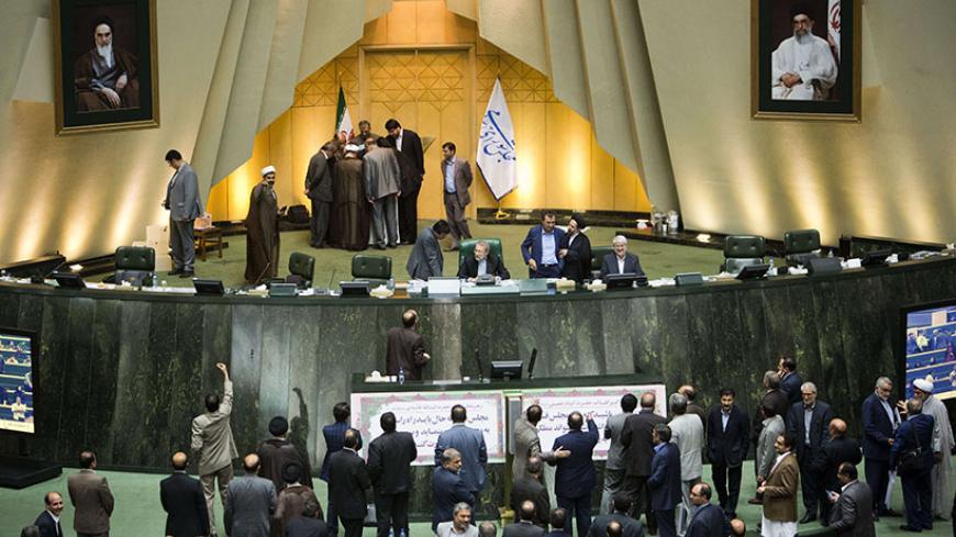 Iranian MPs wait for the results of impeachment of Minister for Science, Research and Technology, Reza Faraji Dana as other MPs (top L) count the ballots after voting at parliament in Tehran on August 20, 2014. Iran's conservative-dominated parliament voted to sack the science minister for wanting to recruit people accused of involvement in the 2009 protest movement. AFP PHOTO/BEHROUZ MEHRI        (Photo credit should read BEHROUZ MEHRI/AFP/Getty Images)