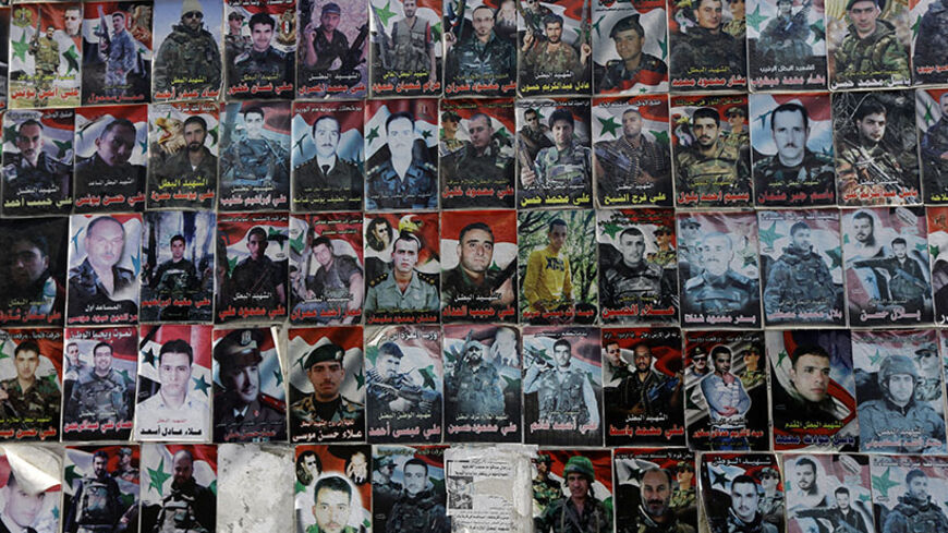 TO GO WITH AFP STORY BY SAMMY KETZ
A memorial bearing the portraits of soldiers from the city of Tartus, who died during the Syrian conflict, is seen on a wall in the city northwest of Damascus on May 18, 2014. Tartus has itself largely escaped the conflict in Syria, but posters of its sons killed fighting for the regime elsewhere in the country line the western city's main road. AFP PHOTO/JOSEPH EID        (Photo credit should read JOSEPH EID/AFP/Getty Images)
