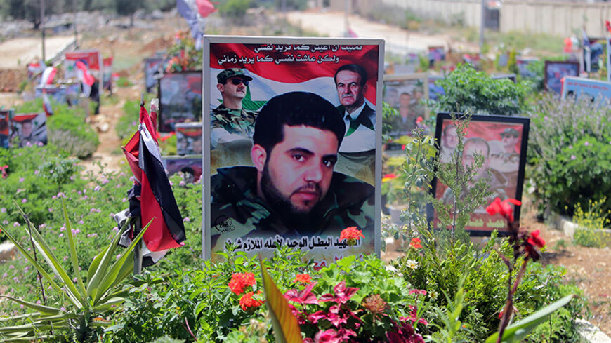 TO GO WITH AFP STORY BY SAMMY KETZ
The portrait of a Syrian soldier, who died during the Syrian conflict, is seen at the Martyr's cemetery of the city of Tartus northwest of Damascus on May 18, 2014. Tartus has itself largely escaped the conflict in Syria, but posters of its sons killed fighting for the regime elsewhere in the country line the western city's main road. AFP PHOTO/JOSEPH EID        (Photo credit should read JOSEPH EID/AFP/Getty Images)