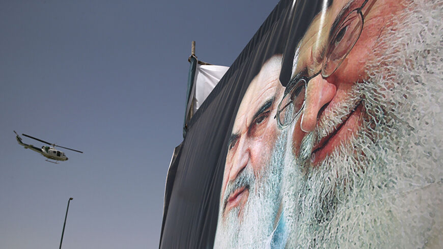 TEHRAN, IRAN - JUNE 04:  An Iranian police helicopter passes above portraits of Iran's supreme leader Ayatollah Ali Khamenei (R) and the former Ayatollah Khomeini outside Khomeini's shrine on the 25th anniversary of his death on June 4, 2014 on the outskirts of Tehran, Iran. Khomeini, the founder of the Islamic Republic, is still revered by many Iranians, and his portrait hangs throughout the country.  (Photo by John Moore/Getty Images)