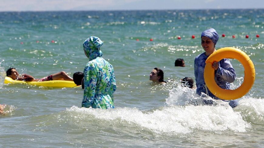 Istanbul, TURKEY:  TO GO WITH AFP STORY BY BURAK AKINCI Turkish women wearing a "hasema", an islamic bathing suit, swim 18 August 2006 at the beach near Istanbul. Last week in Karaburun, a resort near Izmir, a young women was assaulted by a group of Islamists because she was wearing a bikini. AFP PHOTO/MUSTAFA OZER  (Photo credit should read MUSTAFA OZER/AFP/Getty Images)