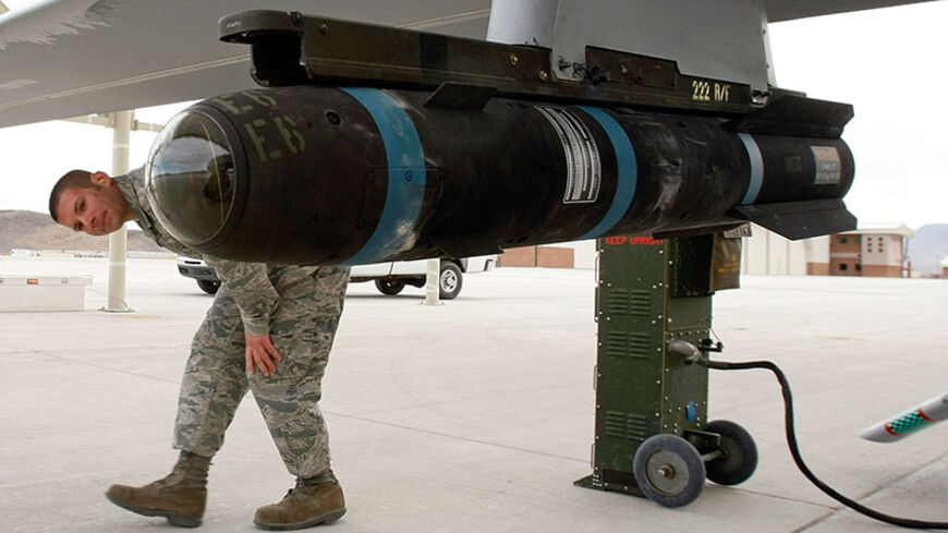 INDIAN SPRINGS, NV - APRIL 16:  Airman 1st Class Ozzy Toma walks around an inert Hellfire missile as he perform a pre-flight check on an MQ-1B Predator unmanned aircraft system (UAS) April 16, 2009 at Creech Air Force Base in Indian Springs, Nevada. The United States Air Force currently has 116 of the aircraft in its UAS fleet with 31 of them airborne at any given moment, flying combat air patrols over Iraq and Afghanistan. After being launched overseas, the Predators are flown by pilots and sensor operator