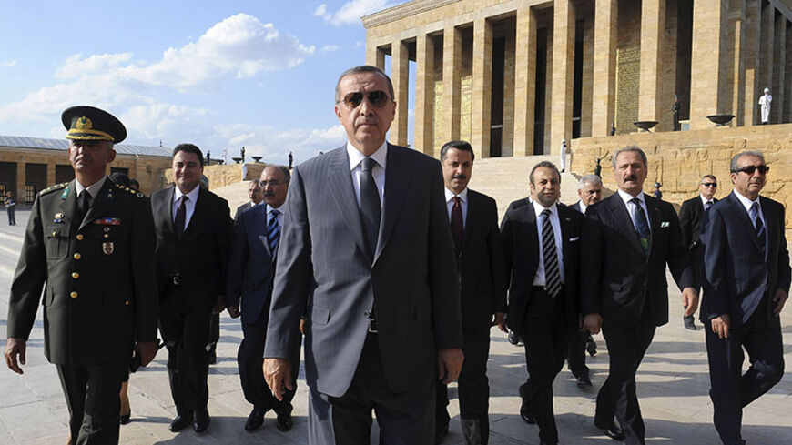 Turkey's Prime Minister Tayyip Erdogan (C) and new cabinet members visit Anitkabir, the mausoleum of modern Turkey's founder Ataturk, in Ankara July 13, 2011. Erdogan's government won a confidence vote on Wednesday to push ahead with plans for a new constitution, but a parliament boycott by Kurdish lawmakers has soured his calls for cross-party consensus. REUTERS/Stringer (TURKEY - Tags: POLITICS IMAGES OF THE DAY TRAVEL) - RTR2OU1K
