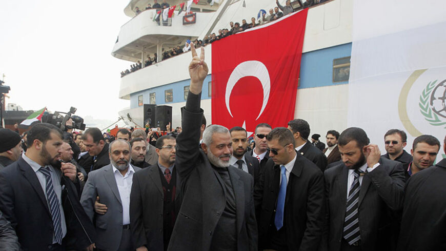 Hamas' Gaza leader Ismail Haniyeh (C) flashes a victory sign to his supporters in front of the cruise liner Mavi Marmara in Istanbul January 2, 2012.  REUTERS/Osman Orsal (TURKEY - Tags: POLITICS TRANSPORT TPX IMAGES OF THE DAY) - RTR2VT9X