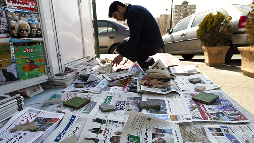 EDITORS' NOTE: Reuters and other foreign media are subject to Iranian restrictions on leaving the office to report, film or take pictures in Tehran.
A man looks at newspapers at a news stand in Tehran March 4, 2012. Hardliners allied with Iran's Supreme Leader Ayatollah Ali Khamenei maintained their lead in the country's parliamentary vote, with partial results on Sunday showing supporters of the president trailing behind. REUTERS/Raheb Homavandi  (IRAN - Tags: POLITICS ELECTIONS) - RTR2YTIX